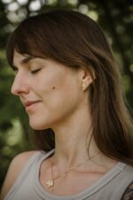 Modelka z pozłacanym kompletem biżuterii RÓZGA kolczyki z listkiem klonu i naszyjnik